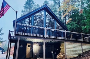 A cabin with a balcony, a flag, and a forested background. - Modern Chalet Near Mt. Sunapee & Lake Massasecum (Bradford)