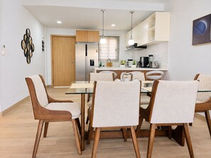 A modern kitchen with a dining area, wooden cabinets, and a central island.