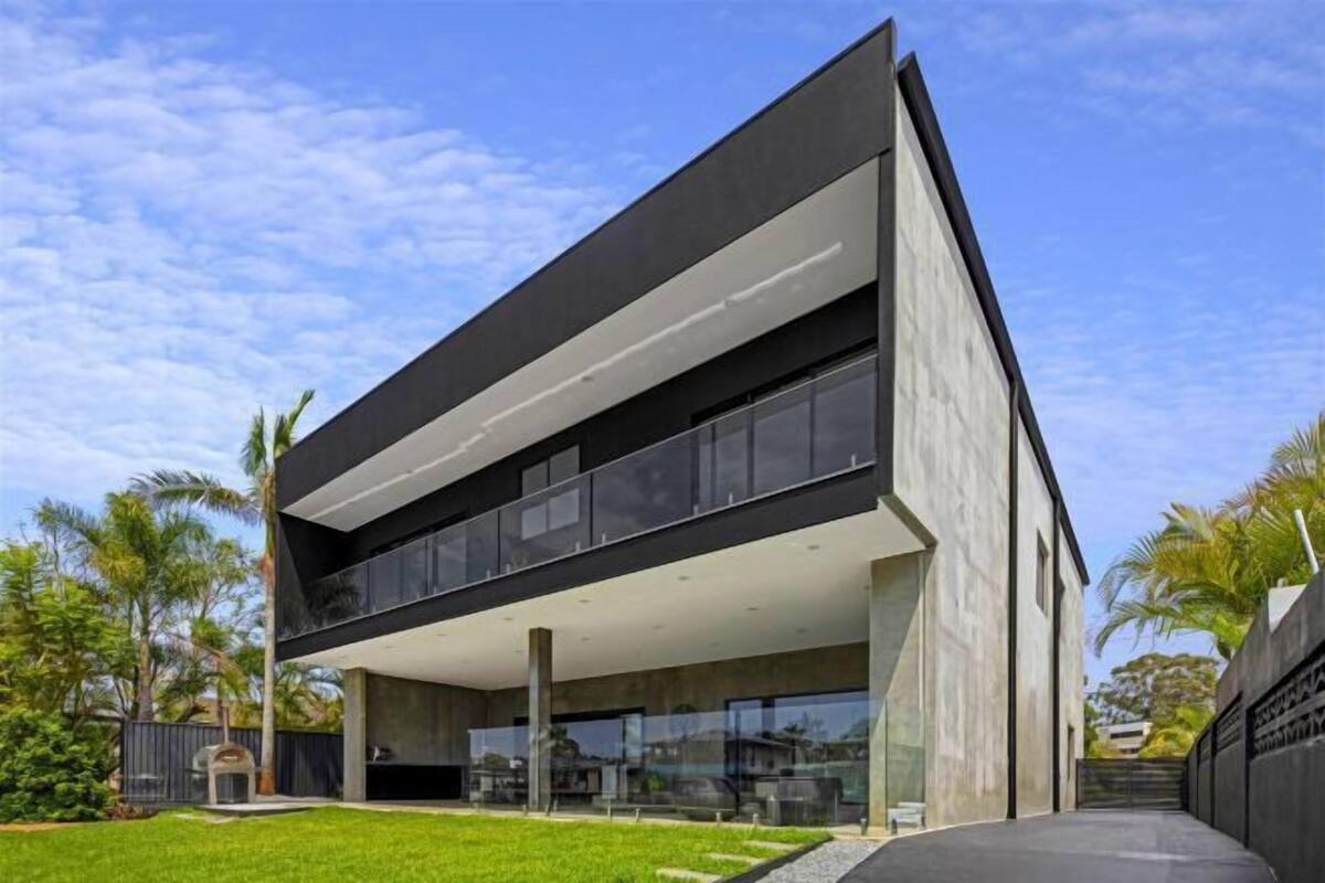 Un bâtiment moderne à deux étages, doté d’un toit plat, de grandes fenêtres et d’une façade en béton.