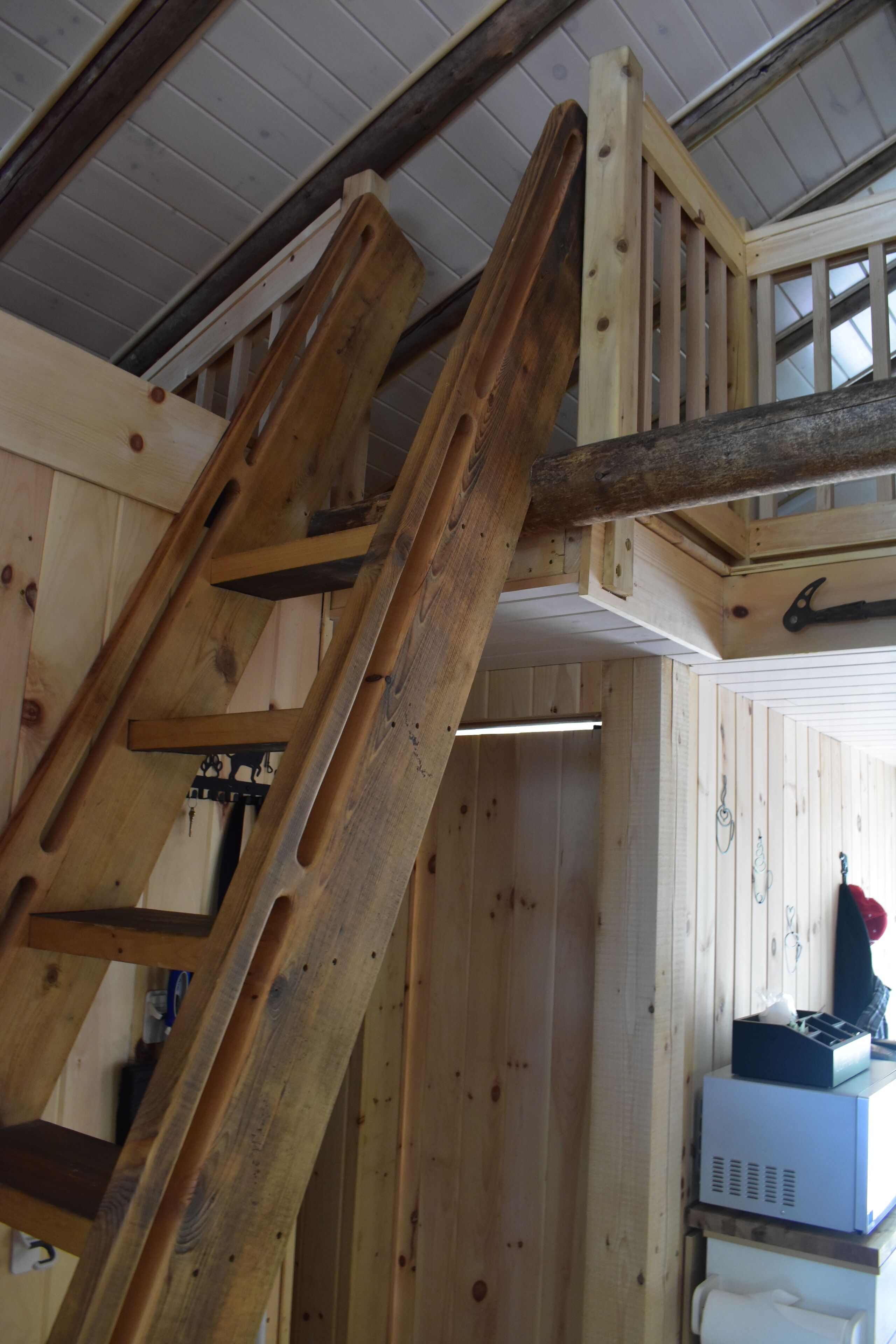 Un escalier en bois, doté d’une rampe, mène à un niveau supérieur.