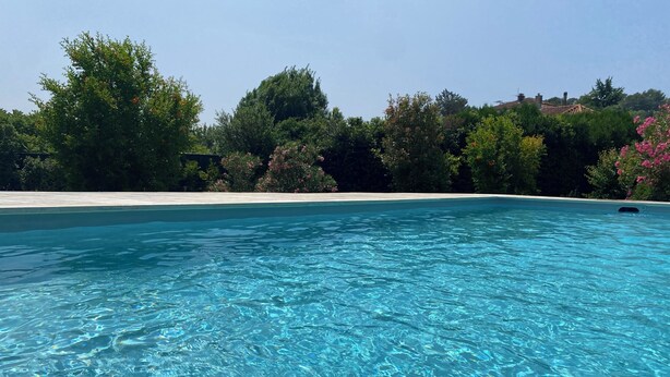 A clear blue pool surrounded by lush greenery and a white sandy area. - Large house with private swimming pool, enclosed grounds that will enchant your vacations.  (Saint-Ambroix)