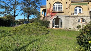A two-story house with a stone facade, arched windows, and a balcony. - Large house with private swimming pool, enclosed grounds that will enchant your vacations.  (Saint-Ambroix)