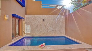 An outdoor swimming pool with a stone wall and wooden deck. - Casa Piedra: 4BR/4BA, Private Pool & Rooftop Palapa, Sleeps 8 San Pancho Nayarit (San Francisco)