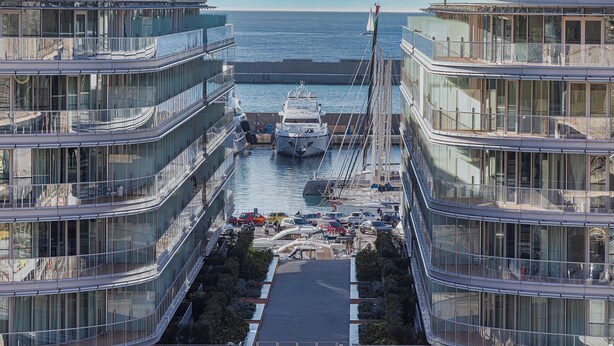 A modern marina with glass-fronted buildings, a docked yacht, and a clear view of the sea. - Waterfront Vibes by Wonderful Italy (Genoa)