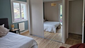 A bedroom with a large mirror, a bed, a bedside table, and a window. - Apartment with private courtyard and parking in Sarlat town center (Sarlat-la-Canéda)