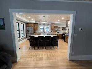 A modern kitchen with a central island, wooden cabinets, and stainless steel appliances.