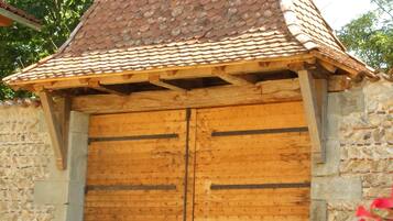 A rustic wooden building with a tiled roof and a large wooden door.