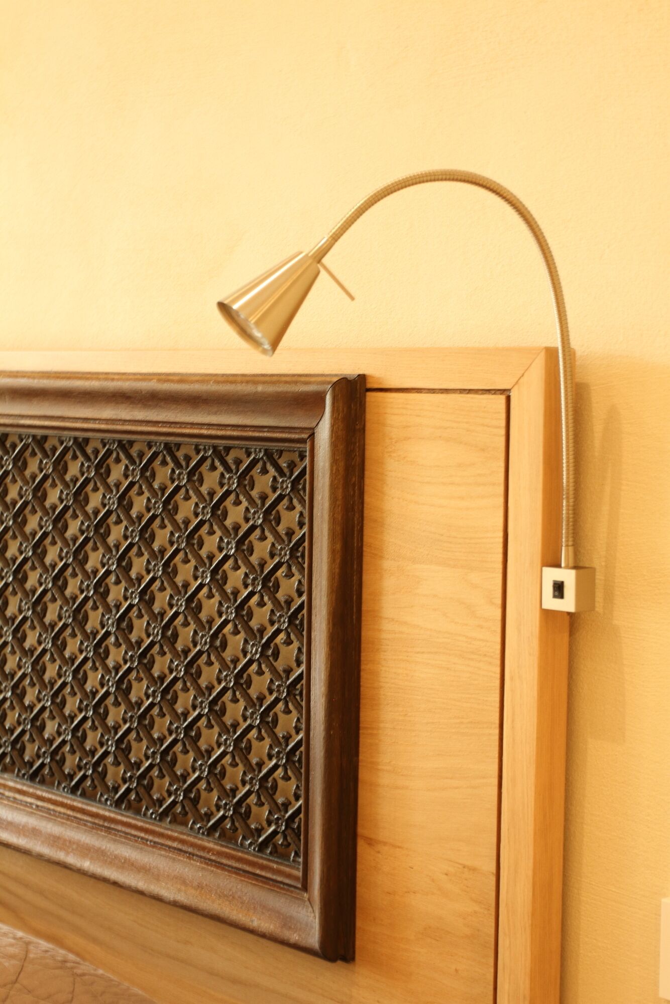 Una lámpara de pared con un brazo curvo y un interruptor.