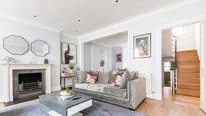 Una sala de estar moderna con chimenea, un sofá gris y una mesa de centro.
