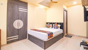 A bedroom with a bed, a wardrobe, a ceiling fan, and a television.