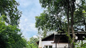 Una casa moderna con garaje, terraza de madera y un sendero de piedra que lleva a la entrada.