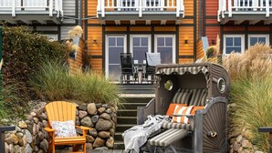A multi-story building with balconies, a deck with outdoor furniture, and a large window. - Family-friendly vacation home "Hafenspaß" with water view, close to the beach (Olpenitz)
