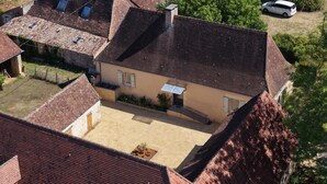 A residential building with a tiled roof, a covered porch, and a small garden area. - Country house in the heart of Périgord Noir in Rouffignac  (Rouffignac-Saint-Cernin-de-Reilhac)