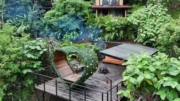 A wooden deck with a heart-shaped planter, a small fire pit, and a solar panel. - Discover Arenal Romantic Cabin Near La Fortuna – Private Hot Tub for Couples (Monterrey, La Fortuna)