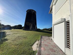 Stunning water tower stands adjacent to a building with a white exterior, surrounded by a paved walkway and lush lawn.