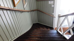 A wooden staircase with a white railing, flanked by framed pictures on the walls. - Wallin House  (Värmlands län)