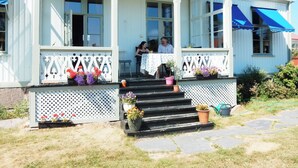 A white building with a porch, steps, and potted plants. - Wallin House  (Värmlands län)