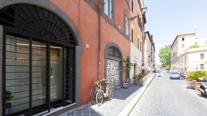 Un carrer pavimentat i estret amb un edifici que destaca per una gran finestra apuntada i una bicicleta aparcada a l'exterior.