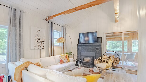 Una sala de estar acogedora con un sofá blanco, una chimenea y un televisor.