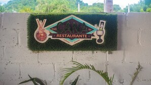 A restaurant sign with a snack and bar symbol, a glass of drink, and a star.