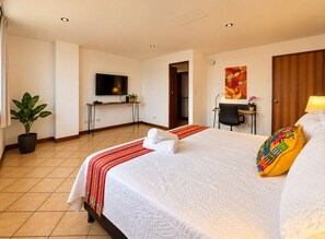 A hotel room with a bed, a desk, a television, and a potted plant. - DP3 4-bedroom apartment with WiFi and great views (Ciudad de Guatemala)