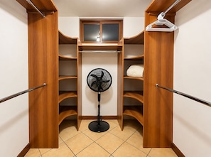 A walk-in closet with wooden shelving, a hanging rack, and a standing fan. - DP3 4-bedroom apartment with WiFi and great views (Ciudad de Guatemala)