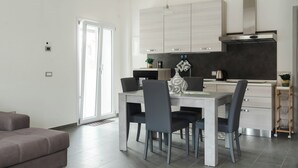 Een moderne keuken met een eethoek, met een grote tafel, stoelen en een inbouwoven.