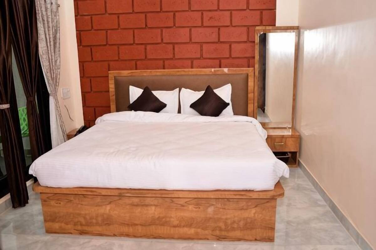 A bed with a wooden frame, white bedding, and two pillows.