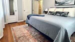 Ein Schlafzimmer mit einem Bett, einem Teppich, einem Deckenventilator und einem Bild an der Wand.