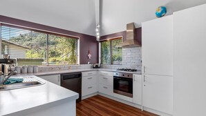 Een moderne keuken met witte kasten, een roestvrijstalen spoelbak en een inbouwoven.