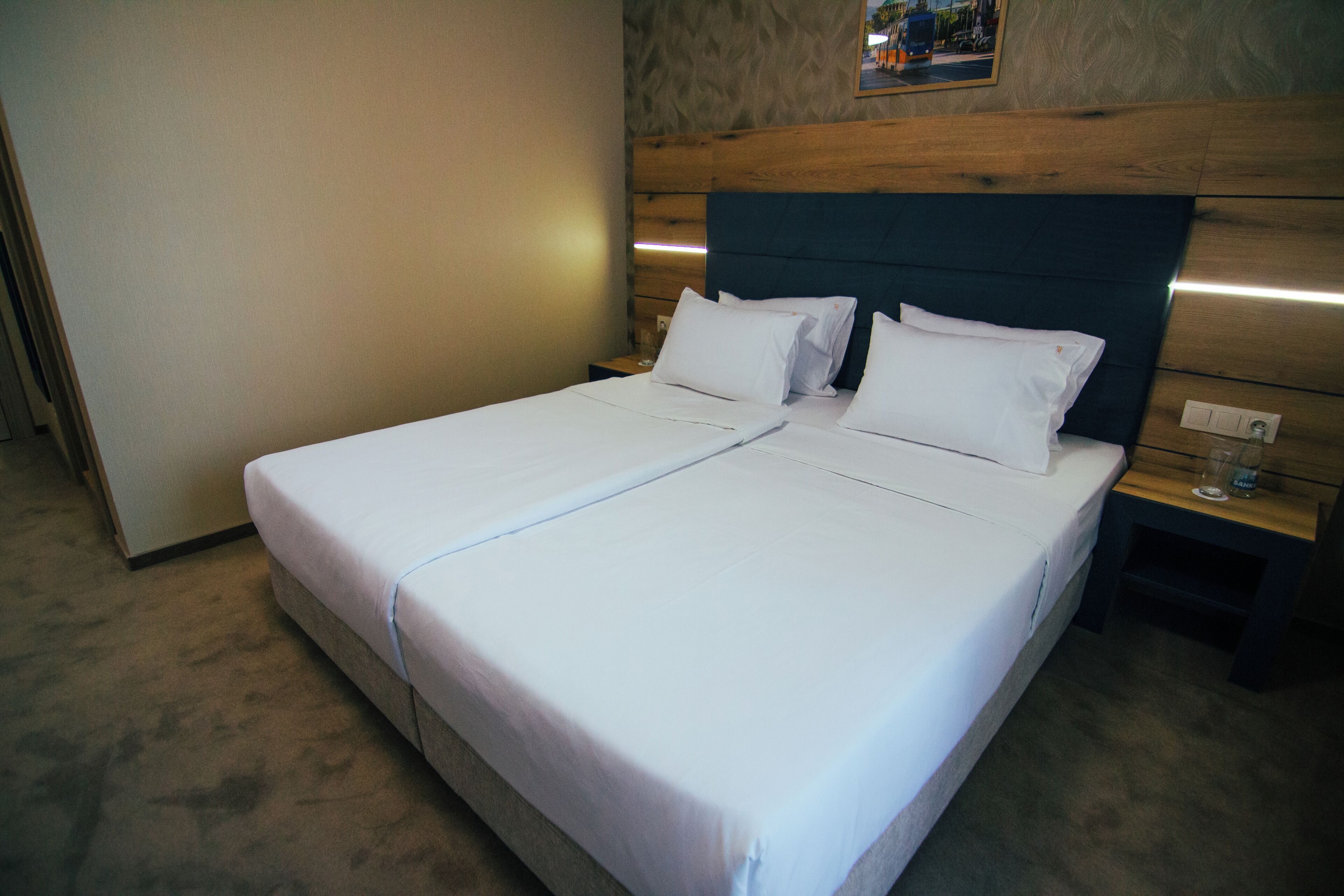 Un lit double avec du linge de lit blanc dans une chambre d’hôtel.