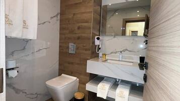 Een moderne badkamer met een houten accentmuur, een marmeren wastafel en een toilet.