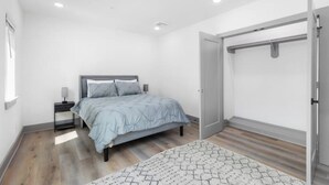 Un dormitorio moderno con cama, mesita de noche y armario.