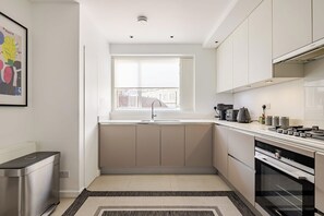 Eine moderne Küche mit Fenster, Edelstahlgeräten und minimalistischem Design.