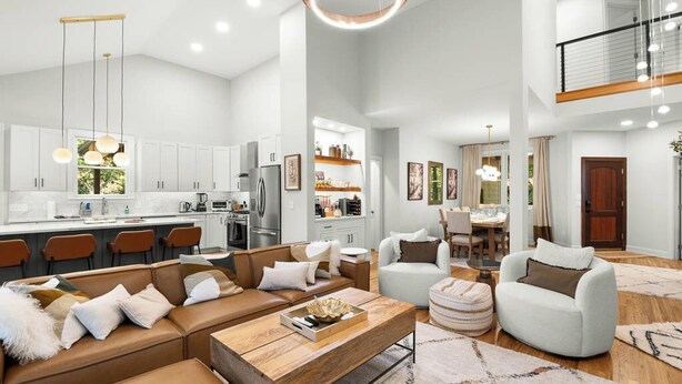 A spacious living area with a large sofa, a coffee table, and a dining area with a table and chairs.