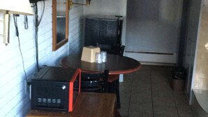 A narrow hallway with a wooden table and a television set. - Dorchester Motel (Redford)