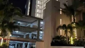A modern building with multiple floors, illuminated windows, and a paved entrance area with palm trees. - Luxury Oceanfront Condo with WiFi, Pool, and Fitness Room in Puerto Vallarta (Puerto Vallarta)