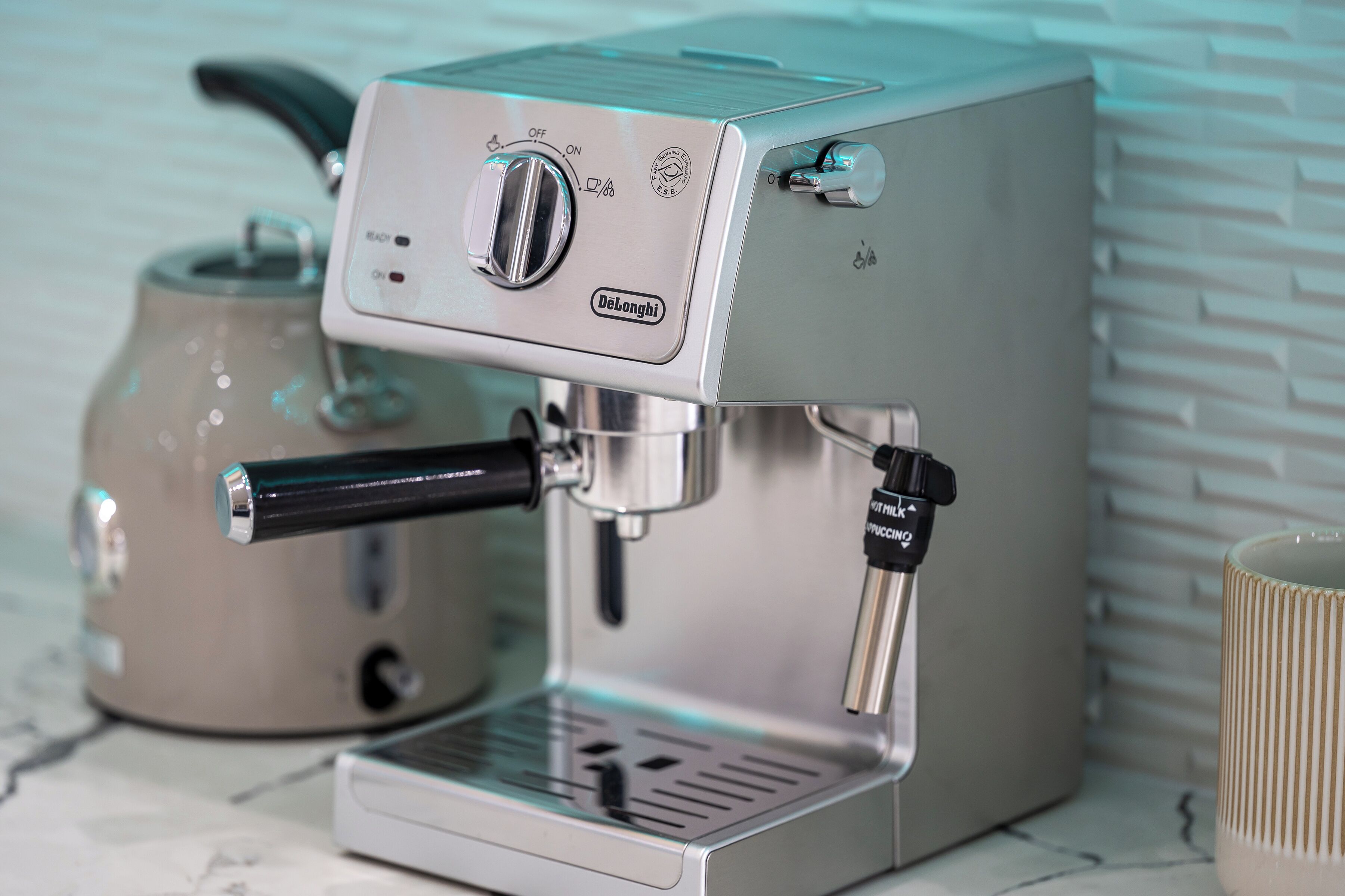 A Delonghi espresso machine with a control panel, a steam wand, and a milk frothing wand.