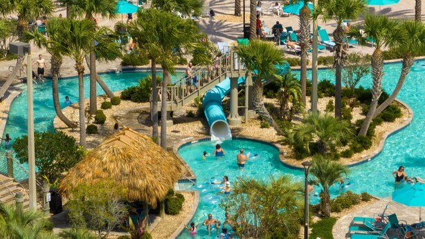A water park with multiple pools, a thatched-roof hut, and a slide. - Free Pool Heat if you Stay in the Month of November (Davenport)