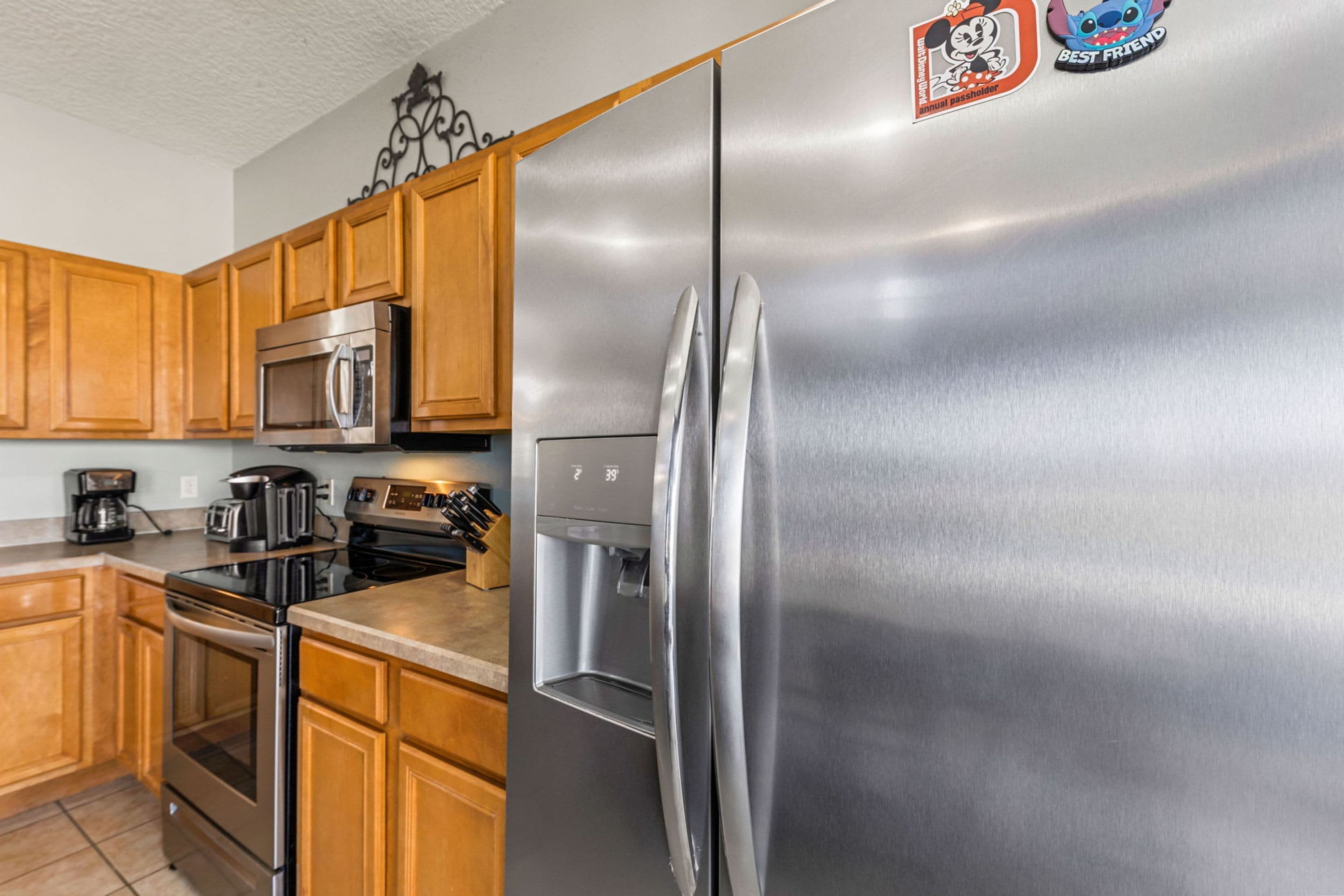 A modern kitchen with stainless steel appliances, wooden cabinets, and a water dispenser.
