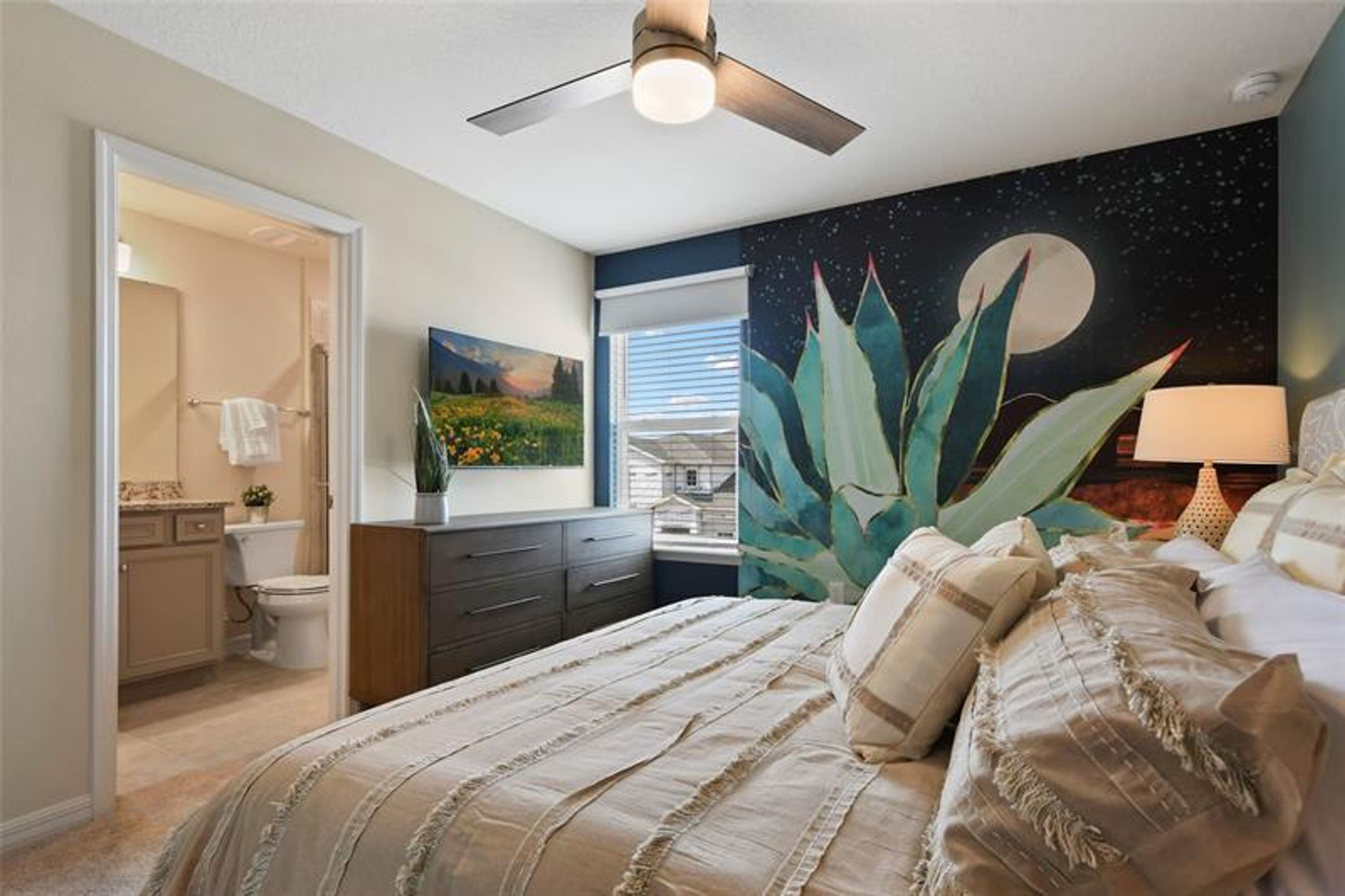 A bedroom with a bed, a night sky mural, a ceiling fan, and a window with blinds.