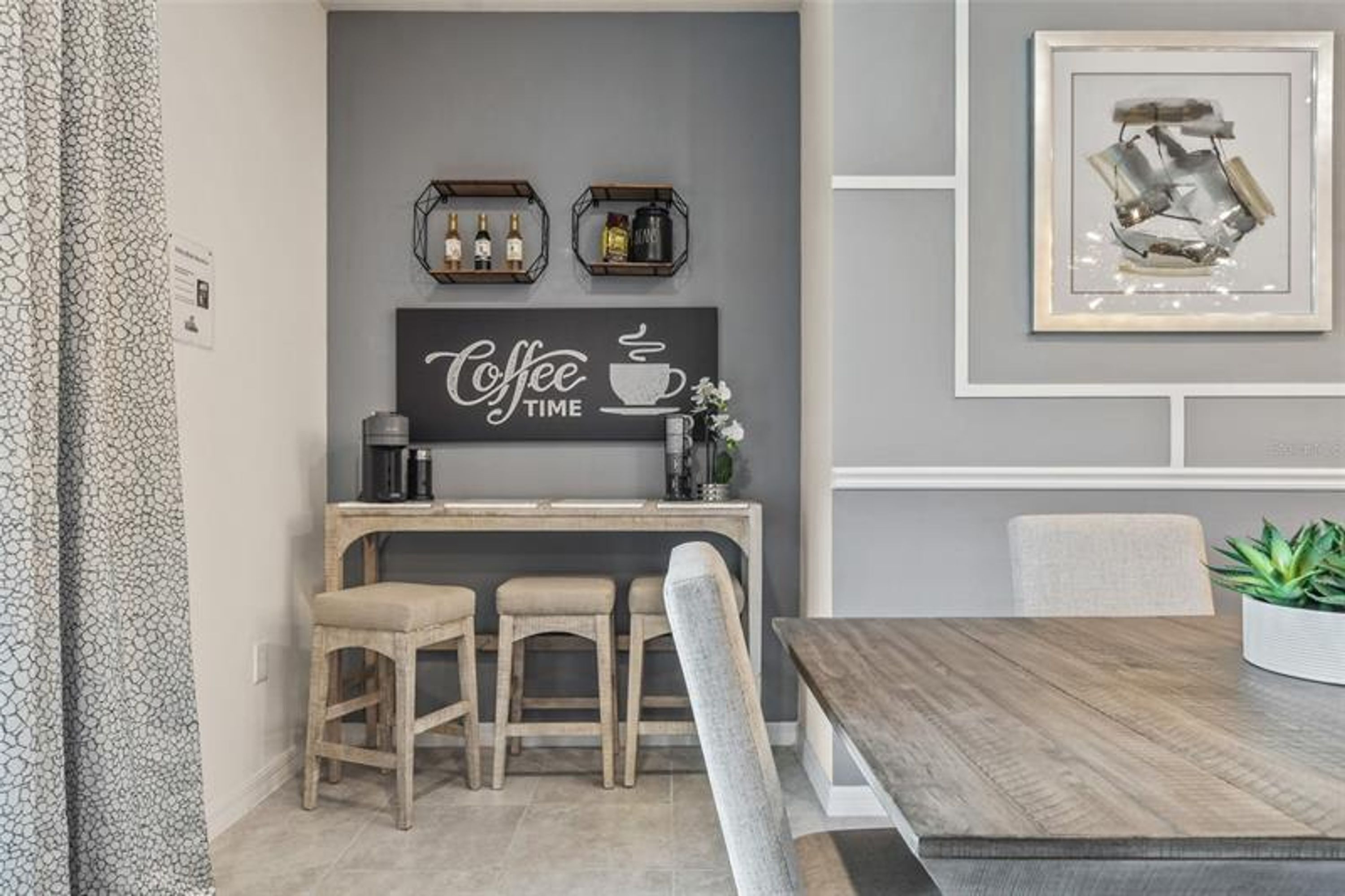 Eine moderne Küche mit einer Kaffeebar, Barhocker und einem Esstisch.