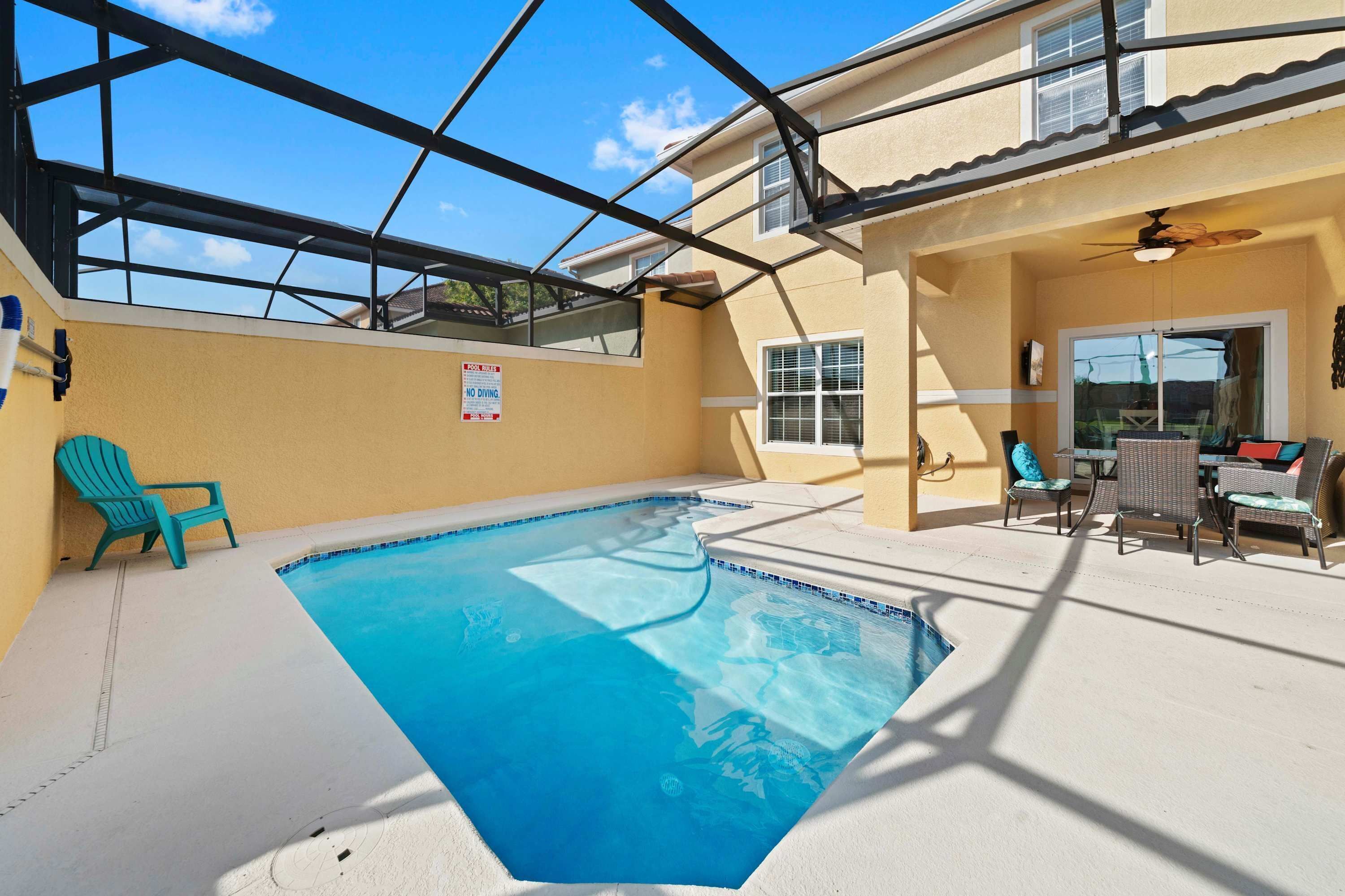 A swimming pool with a glass ceiling, a 'NO DIVING' sign, and outdoor seating.