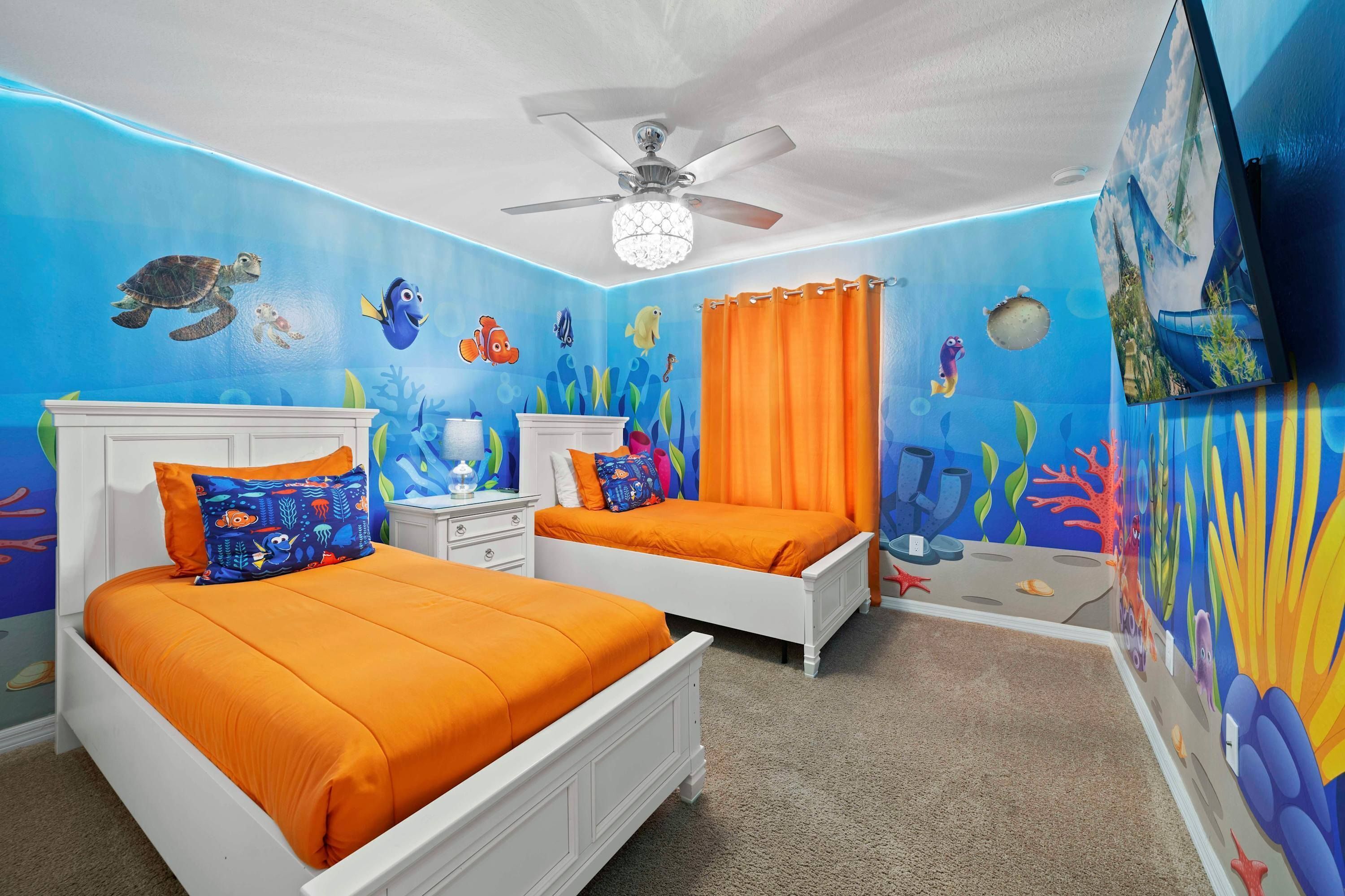 Een slaapkamer met twee bedden, een oranje gordijn en een plafondventilator.