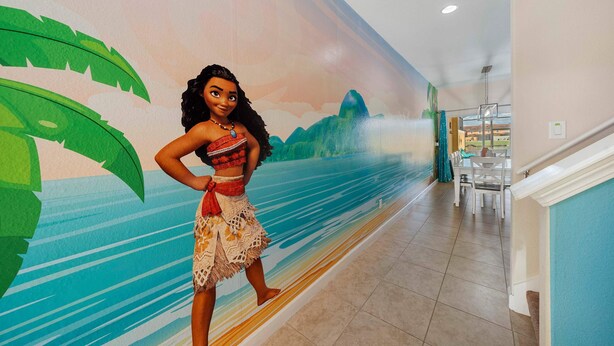 Une personne se tient dans un couloir, et sur le mur, on peut voir une fresque représentant un paysage tropical.
