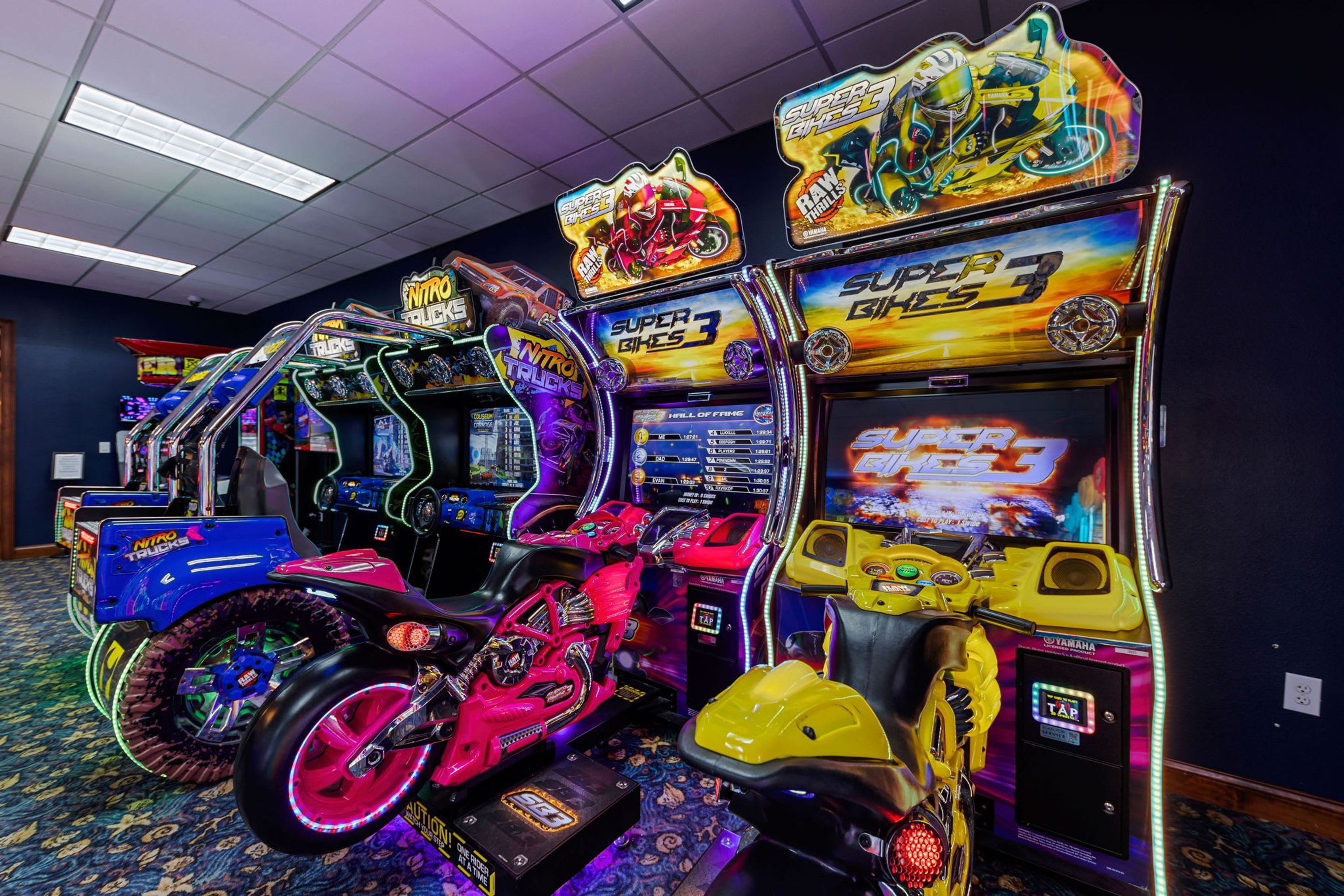 Máquinas de arcade con luces de neón y temática de carreras.