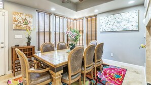 A dining area with a wooden table and chairs, a ceiling fan, and artwork on the walls. - Beautiful Sunsets at 3BR Villa in Reno (Reno)