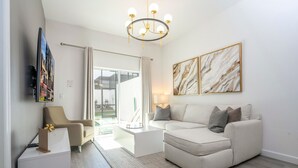 Un salon moderne avec un canapé, une table basse et des œuvres d’art accrochées aux murs.