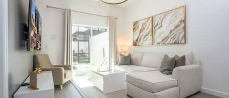 A modern living room with a sofa, coffee table, and artwork on the walls.