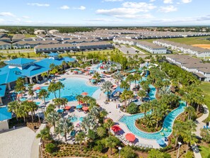 A resort with a large central pool, multiple smaller pools, and a water slide.